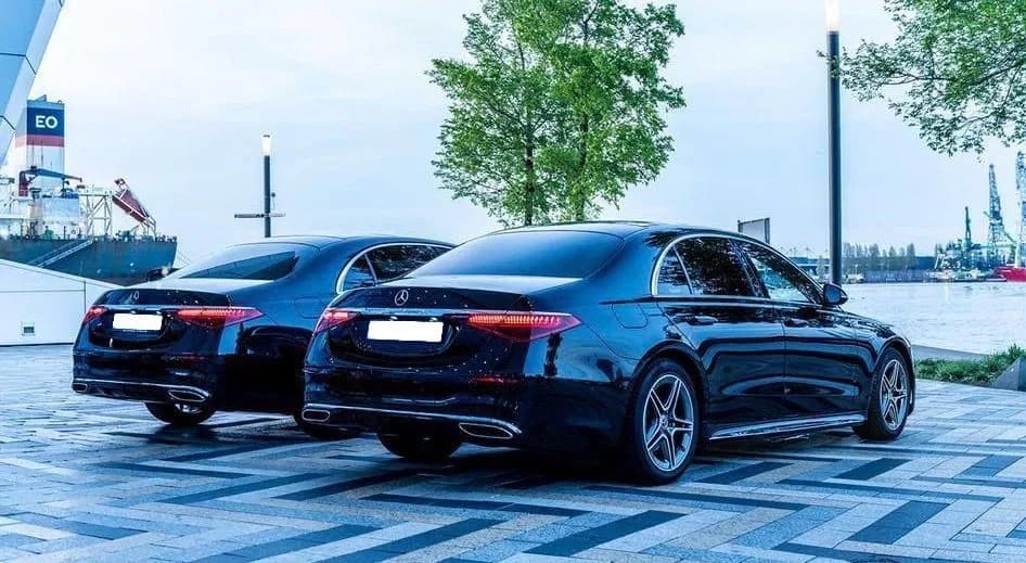 Twee zwarte Mercedes S-Class aan het water in de avondschemering