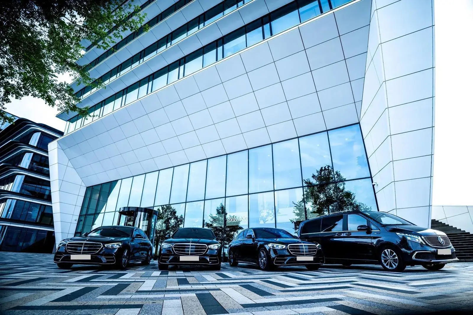 SchipholRide Van- en VIP-voertuigen: Mercedes V-Klasse en S-Klasse voor een glazen kantoorgebouw